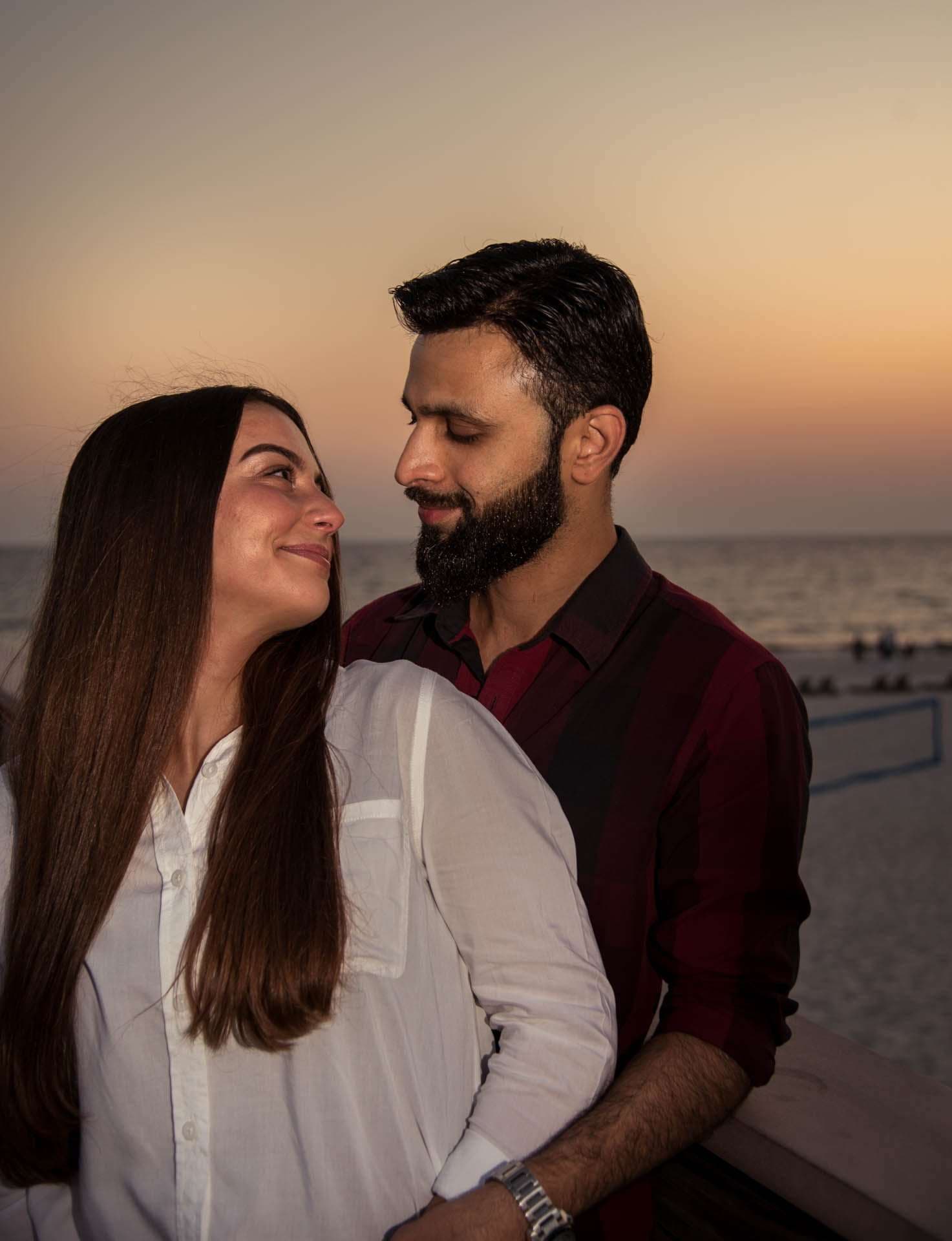 Couple smiling and gazing at each other on the Panama City Beach City Pier at sunset, ocean behind them